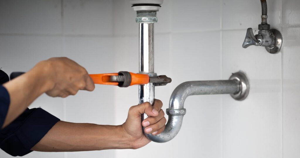 A plumber fixing a leaking pipe.