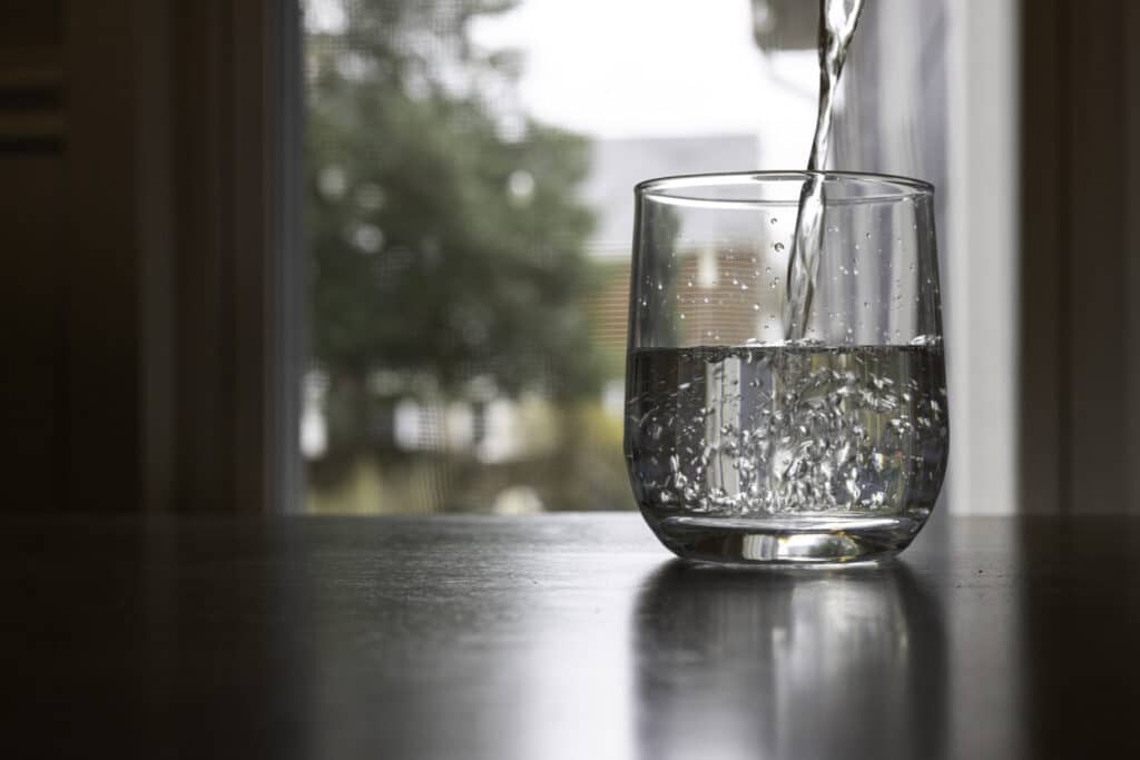 water pouring into glass on countertop